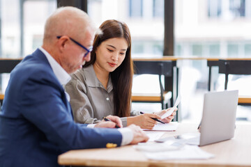 Obraz premium Group of confident business people point to graphs and charts to analyze market data, balance sheet, account, net profit to plan new sales strategies to increase production capacity. 