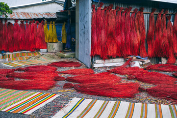 Dyed red reeds are dried at village handicraft factory for the production of traditional Vietnamese...