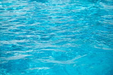 Ripped water in swimming pool. Surface of blue swimming pool, background of water.