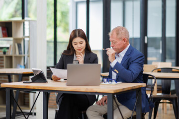 Group of confident business people point to graphs and charts to analyze market data, balance sheet, account, net profit to plan new sales strategies to increase production capacity.	