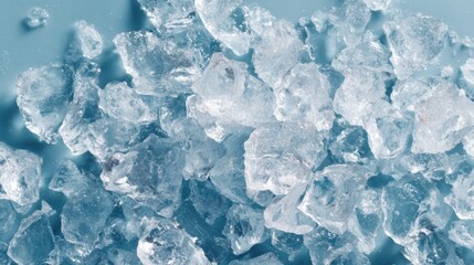 Obraz premium Clear ice crystals are scattered across a blue surface, showcasing their unique textures and shapes.