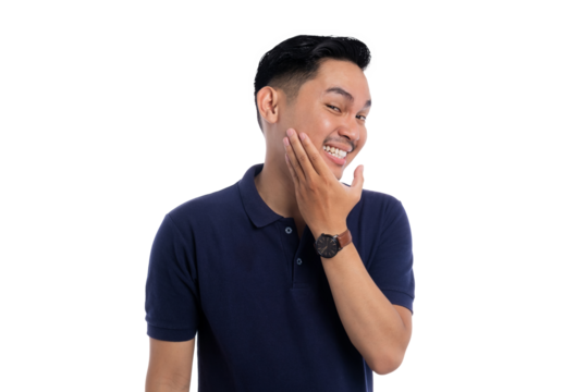 Playful smiling man touching face with one hand while showing bashful expression isolated on transparent background