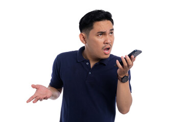 Frustrated young man arguing through voice message on smartphone with angry expression wearing navy...
