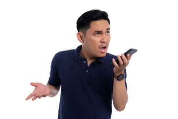 Frustrated young man arguing through voice message on smartphone with angry expression wearing navy blue polo shirt isolated on transparent background