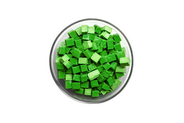 a bowl of green legos on a white surface