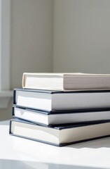 Stack of blue and white books on white table, minimalist background with space for text