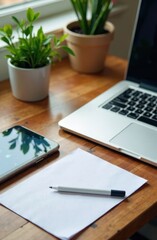 Wooden desk by window with blank paper, pencil, laptop and tablet, indoor plants. Perfect for workspace inspiration, blog visuals, and productivity content. 