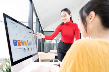 Businesswoman analysis giving a statistic presentation with her colleague in a  boardroom.
