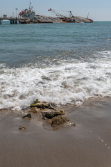 The beach at Marina di Massa, Italy, threatened by a large ship stranded on the rocks