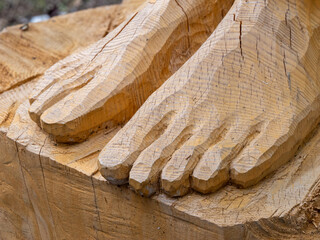 Close-up wooden carving of human feet