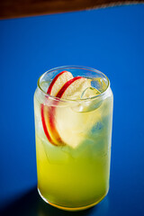 A vibrant cocktail with green hues and fresh apple slices adds charm to a lively gathering