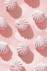 Pink zephyr, marshmallow on Pastel Pink Background, Top view repeated pattern of swirled meringue...