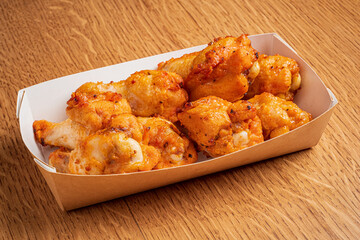 Golden brown fried chicken pieces arranged neatly in a takeout box filled with savory goodness
