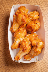 A tray filled with golden, crispy chicken wings awaits to be savored at a casual gathering
