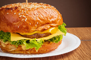Juicy cheeseburger with fresh lettuce and melted cheese awaits a tasty bite on a plate