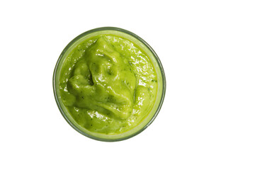 a glass bowl filled with green liquid on a white surface