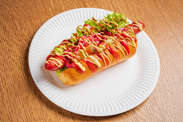 Freshly made hot dog adorned with vivid toppings, presented invitingly on a paper plate