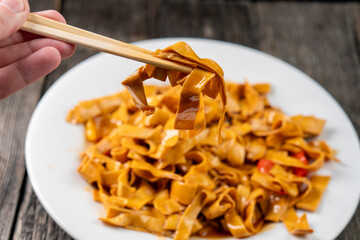 Tofu noodles on dark background. Soy cheese. Vegan food.