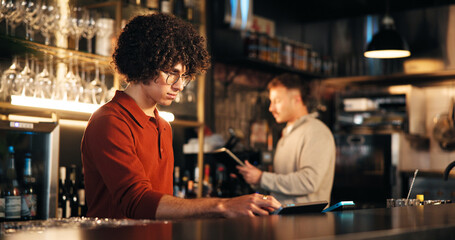 Business, man and bartender in restaurant, tablet and digital app for inventory, counter and internet. People, employees and hospitality with technology, alcohol or customer service with drinks order