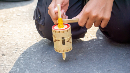 Model a spinning top, made of bamboo and wood wrapped with rope.