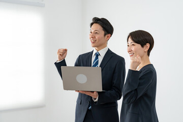 ガッツポーズをする男女のビジネスマン