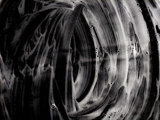 Abstract shape of white cleansing washing soap foam on dark backdrop. Soap water background. Clean...