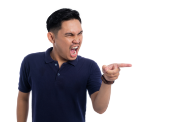 Angry young man yelling and pointing finger with furious expression wearing navy blue polo shirt isolated on transparent background