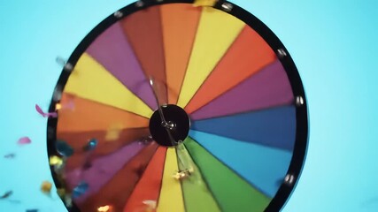 Colorful spinning wheel with confetti against blue