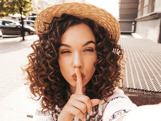 Beautiful model with afro curls hairstyle dressed in summer hipster dress and hat.Carefree female...