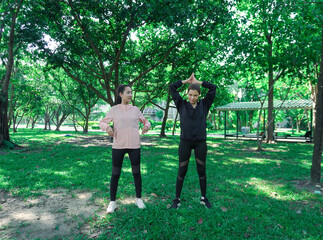 Asian woman in sportswear stretching and warming up before morning jogging. Sports training, jogging in city park.