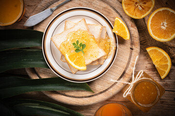 Delicious toast with sweet jam placed on a plate on a wooden board.