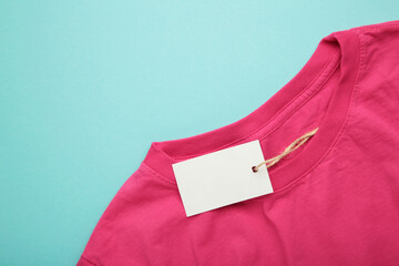Price tag over pink t-shirt on blue background
