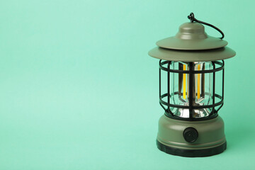 One lantern lamp on mint background. Camping. Space for text