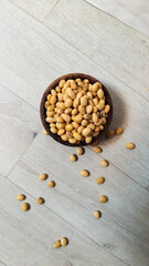 Raw soybeans in coconut bowl on wooden background 