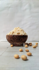 Close up Raw soybeans and soybeans flour in coconut bowl on wooden table 