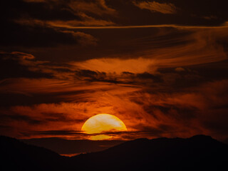 荒れた天気で雲が渦巻く中に沈む夕陽