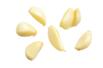 a group of peeled garlic on a white surface