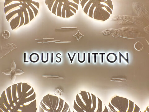 Bangkok, Thailand - June 21, 2025: Illuminated Louis Vuitton logo with tropical leaf design at LV The Place Bangkok