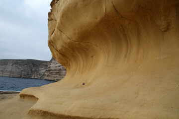 Sandstone wave, formed by wind and weather on the coast of the Xlendi-Xlendi Bay, Gozo, Malta