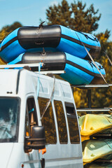 Van hauling boats on road in green park setting