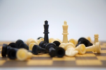 A close-up shot of a chessboard showing the final moments of a game. The fallen pieces and standing...