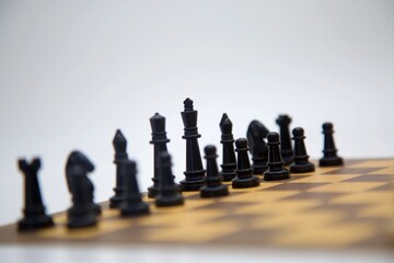 The Black King leads his Army. A view of a chessboard with black pieces arranged in a strategic...