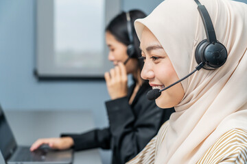 Young adult muslim women in headsets providing customer support in office. Friendly call center...