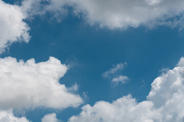 Background of a deep blue summer sky and fluffy white clouds