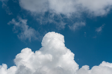 Background of a deep blue summer sky and fluffy white clouds