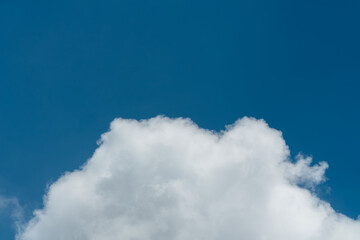 Background of a deep blue summer sky and fluffy white clouds