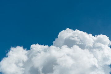 Background of a deep blue summer sky and fluffy white clouds