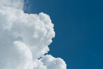 Background of a deep blue summer sky and fluffy white clouds