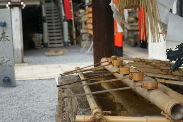 Tsukubai water basin with ladle, called a chozuya or temizuya, at the entrance of a Shinto shrine where visitors cleanse themselves by washing hands and mouth