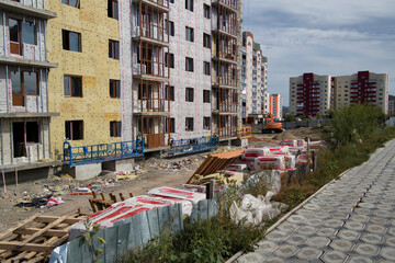 Modern apartment building under construction. Urbanization. Blue sky. Sunny day